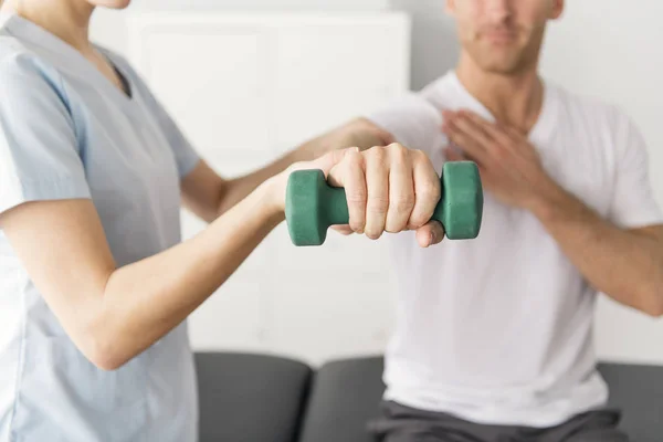 Patient in der Physiotherapie macht körperliche Übungen mit seinem Therapeuten — Stockfoto