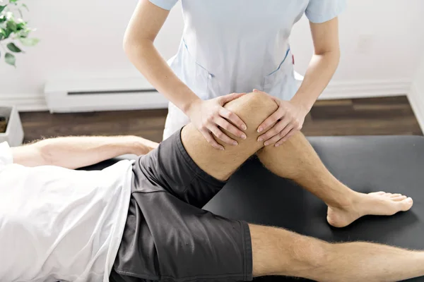 Patient at the physiotherapy doing physical exercises with his therapist — Stock Photo, Image