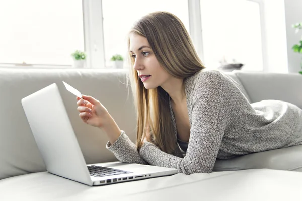 Jonge vrouw op een sofa in de woonkamer — Stockfoto