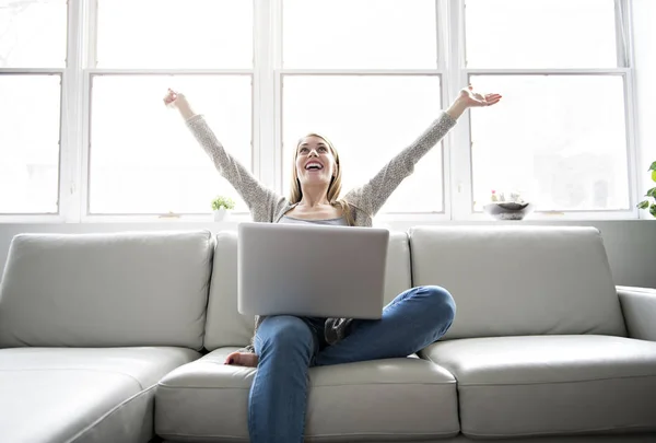 Jonge vrouw op een sofa in de woonkamer — Stockfoto