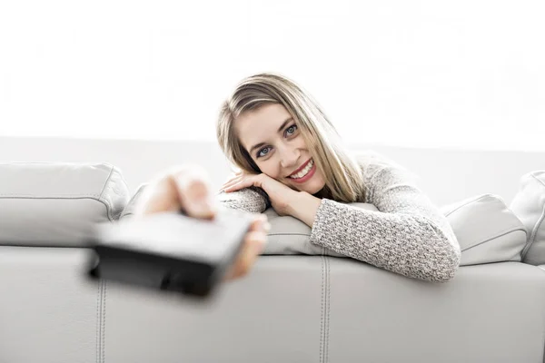 Ung kvinna på en soffa på vardagsrummet — Stockfoto