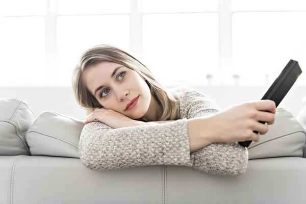 Young woman on a sofa on the living room — Stock Photo, Image