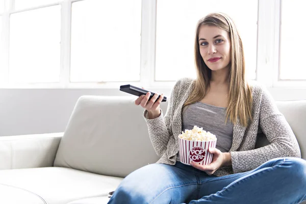 Jeune femme sur un canapé dans le salon — Photo