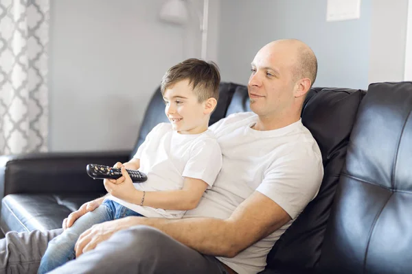 Man and young boy with remote control tv — Stock Photo, Image