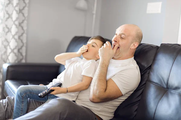 Homem e menino com controle remoto bocejo — Fotografia de Stock