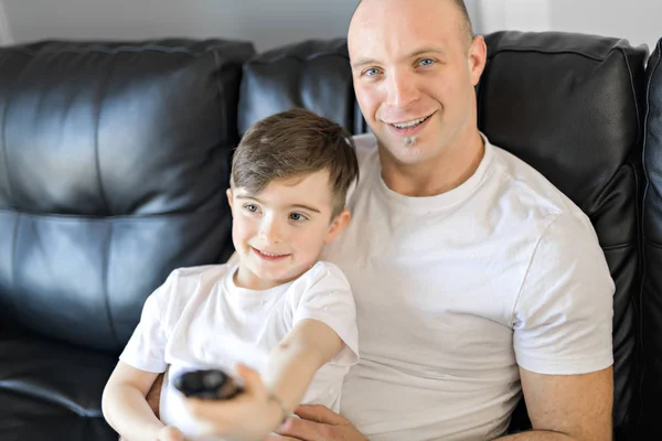 Hombre y niño con control remoto tv — Foto de Stock