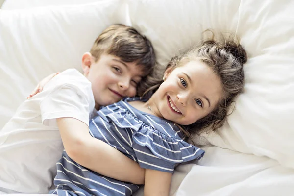 Irmão e irmã se divertindo juntos na cama — Fotografia de Stock