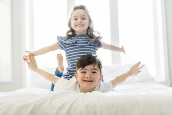 Hermano y hermana se divierten juntos en la cama — Foto de Stock