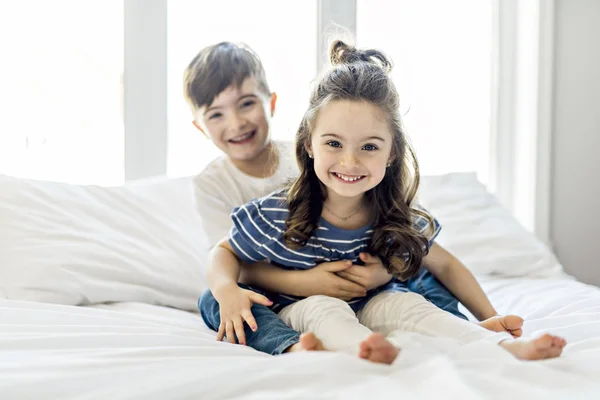 Irmão e irmã se divertindo juntos na cama — Fotografia de Stock