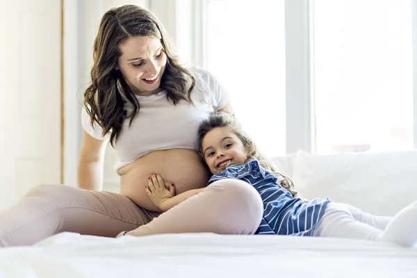 Mulher grávida com sua filha no quarto juntos — Fotografia de Stock