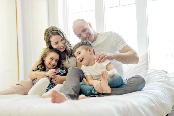 Familia con niños pequeños a la cama en el dormitorio — Foto de Stock