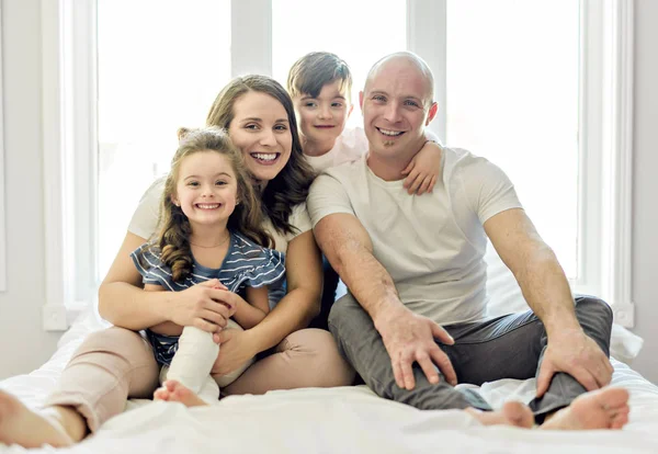 Familia con niños pequeños a la cama en el dormitorio — Foto de Stock