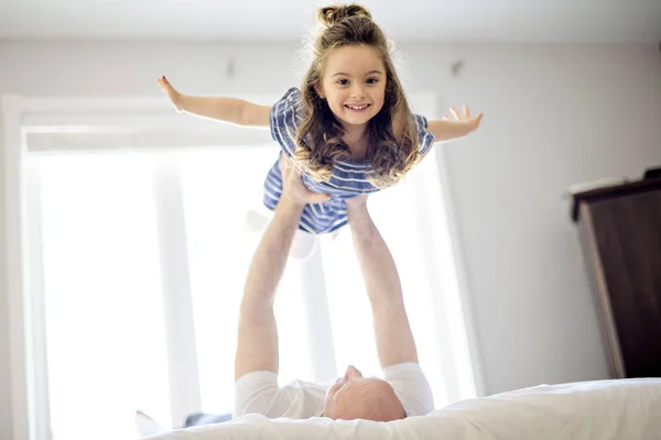 幸せな父と娘のベッドの上で一緒に楽しんで — ストック写真