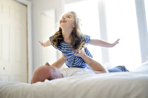 Heureux père et fille s'amuser ensemble sur un lit — Photo