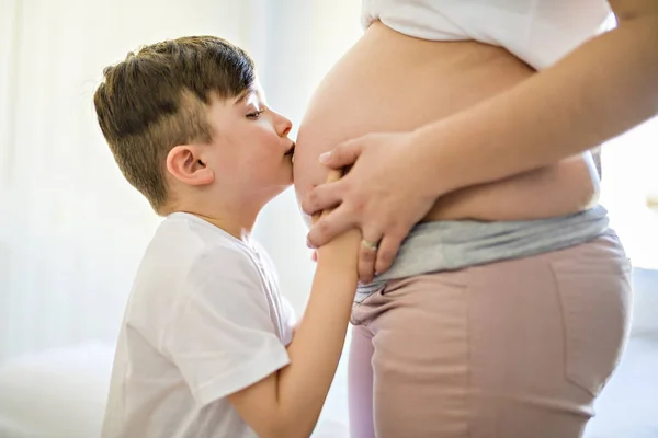 Беременная женщина с сыном в спальне вместе — стоковое фото