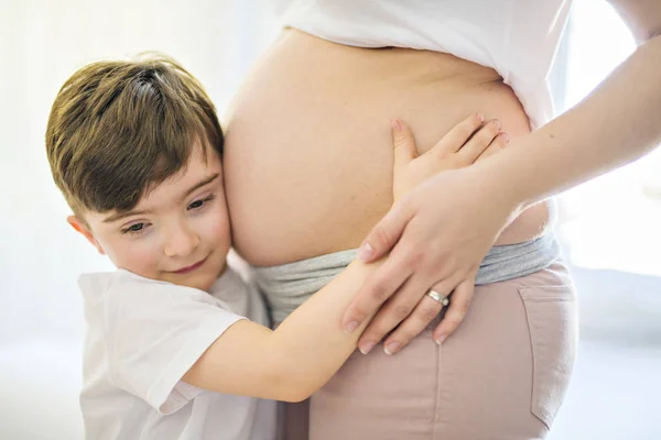 Těhotná žena se svým synem na ložnici dohromady — Stock fotografie