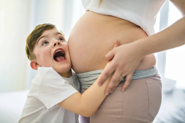 Těhotná žena se svým synem na ložnici dohromady — Stock fotografie