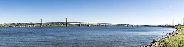 Largo puente colgante se extiende por el río San Lorenzo entre Montmorency y la pintoresca isla de Ile dOrleans en Quebec, Canadá . — Foto de Stock