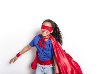 Portrait of girl in superhero costume against grey background clipart