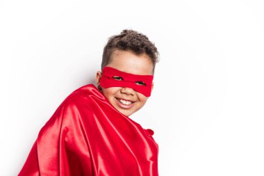 Portrait of boy in superhero costume against grey background clipart