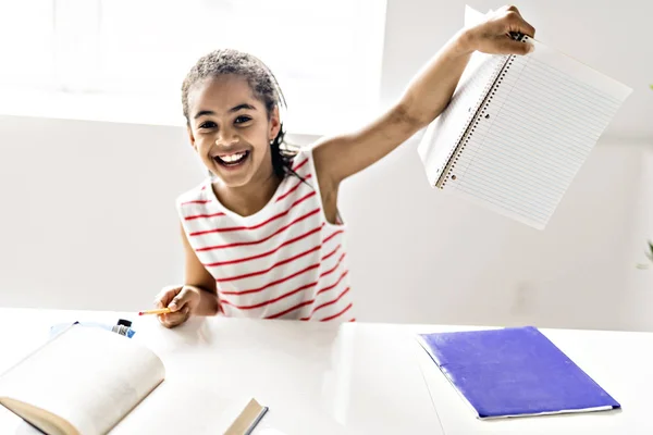 Uma linda garota negra fazendo lição de casa em casa — Fotografia de Stock