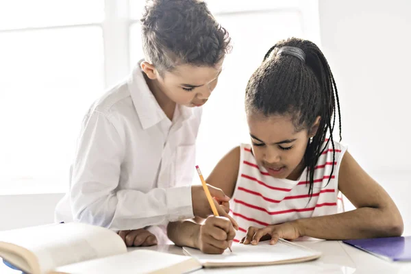 Два черных ребенка делают домашнее задание дома — стоковое фото