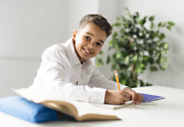 Un lindo negro chico haciendo tarea en casa — Foto de Stock