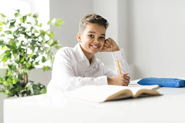 Un garçon noir mignon faisant des devoirs à la maison — Photo