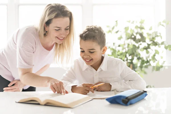 Допомогти матері чорний хлопчик робить домашнє завдання в домашніх умовах — стокове фото