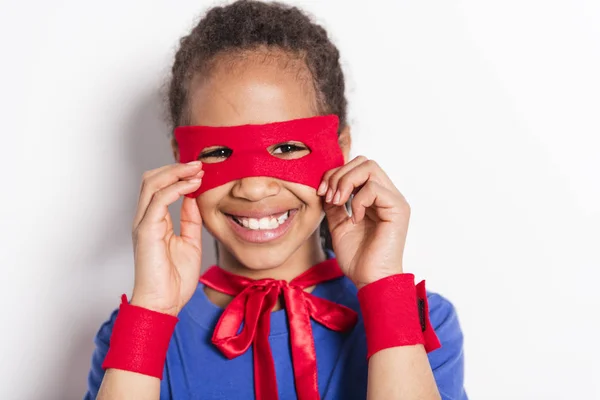 Portrait of girl in superhero costume against grey background — Stock Photo, Image