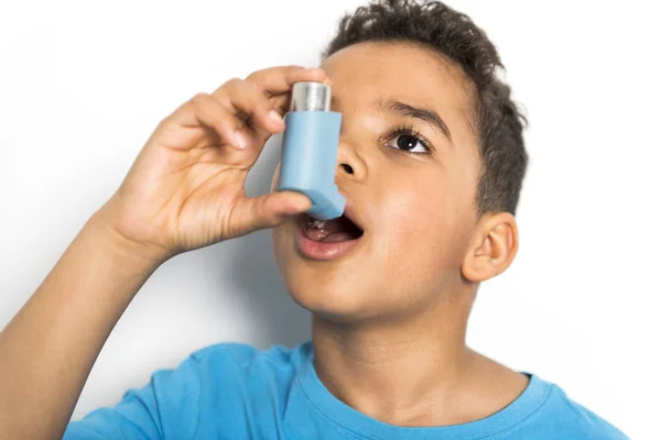 Um menino negro usando um inalador de asma — Fotografia de Stock