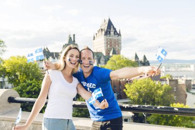 Couple celebrates the national holiday in front of Chateau Frontenac in quebec city clipart
