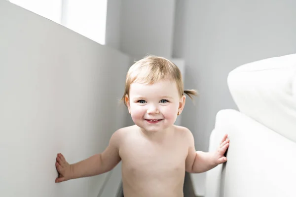 Um ano menina bebê no lado da cama — Fotografia de Stock