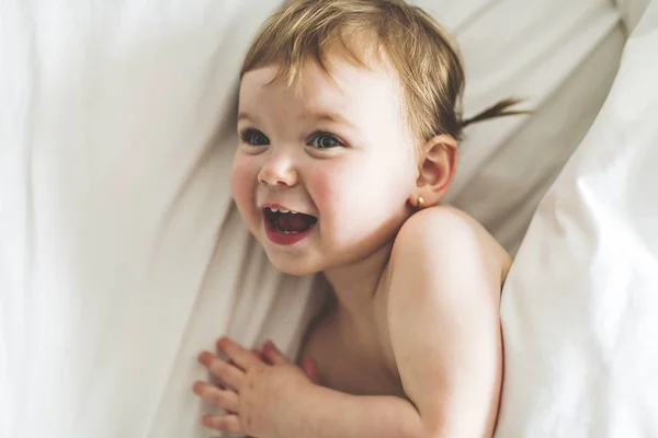 Één jaar meisje baby op het bed — Stockfoto