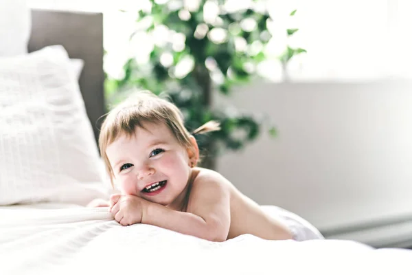 Un bébé fille ans sur le côté du lit — Photo
