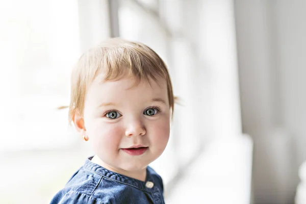 Schattig meisje poseren dicht bij een raam bij u thuis — Stockfoto