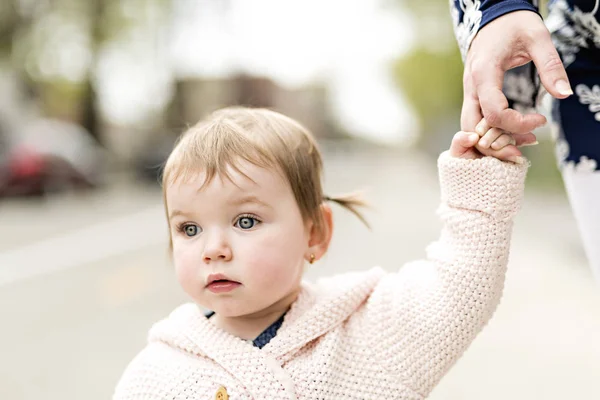 Jong meisje hand in hand met haar ouders buiten — Stockfoto