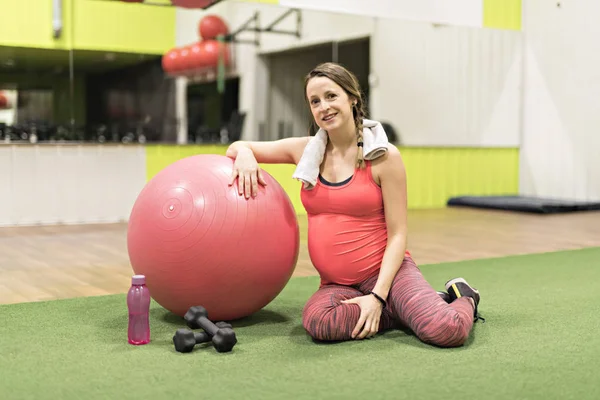 Een zwangere vrouw is het doen van oefeningen in de sportschool — Stockfoto