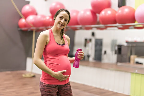 Uma mulher grávida está fazendo exercícios no ginásio — Fotografia de Stock