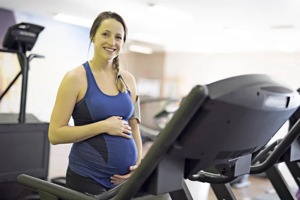 Uma mulher grávida está fazendo exercícios no ginásio — Fotografia de Stock