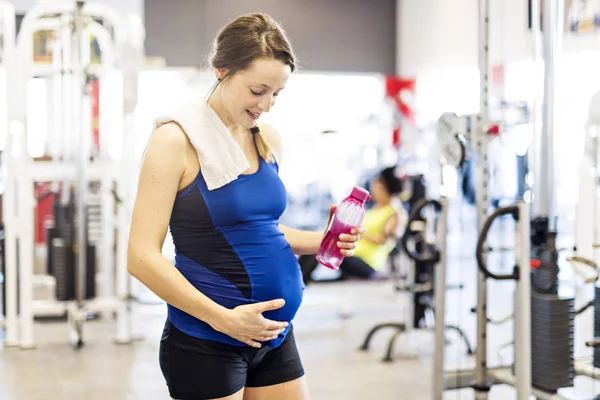 Беременная женщина делает упражнения в спортзале — стоковое фото