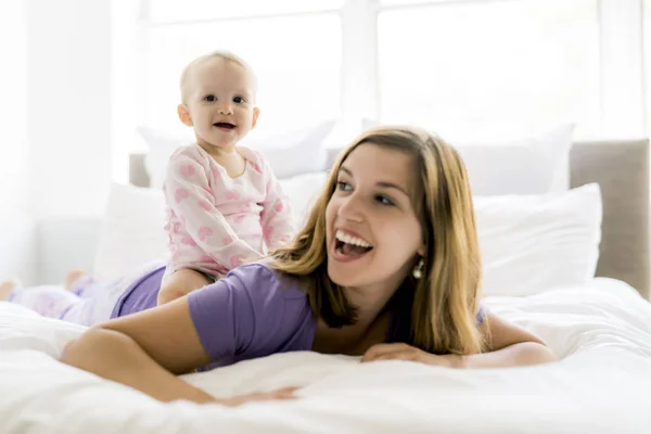 Boldog anya és baba ágyon otthon — Stock Fotó