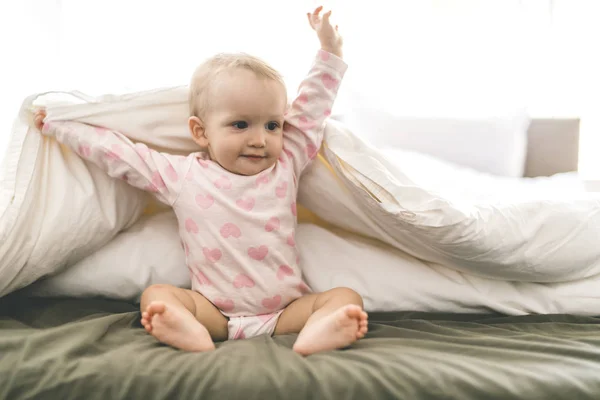 Entzückende Babydecke mit weißem Laken in rosa Kleidung — Stockfoto