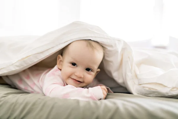 Adorable couverture de bébé fille avec feuille blanche portant des vêtements roses — Photo