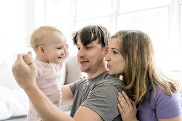 家族が自宅のソファの上の赤ちゃんと一緒に楽しい時を過す — ストック写真