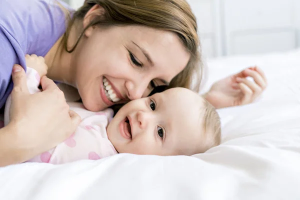 Boldog anya és baba ágyon otthon — Stock Fotó