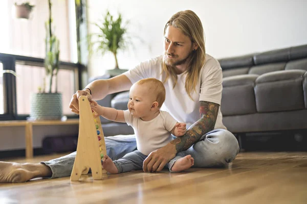 Alegre padre jugando con su niña en el suelo en la sala de estar —  Fotos de Stock