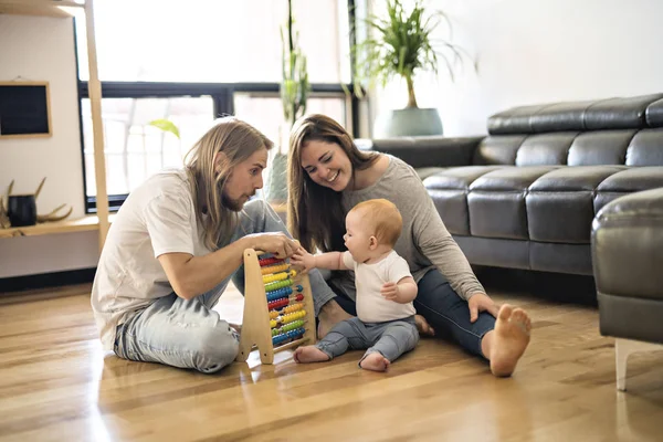 陽気な親が居間で床に彼女の赤ちゃんと遊ぶ — ストック写真