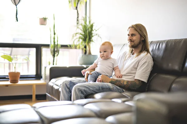 Padre jugando con bebé hija en sofá en casa —  Fotos de Stock