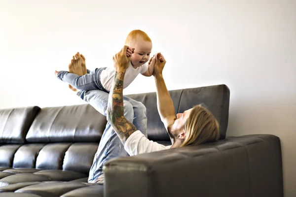 Père jouer avec bébé fille sur canapé à la maison — Photo